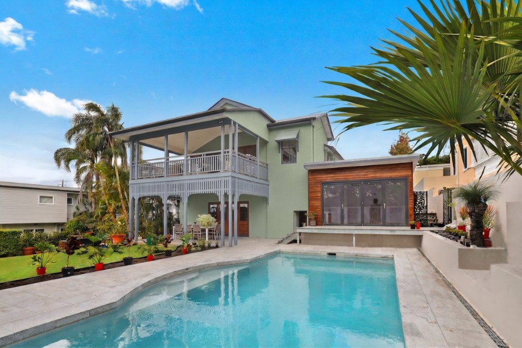 Two-story pool house with sage-green walls, a gray balcony, and a wood-clad wing, previewed with a selectable exterior paint color